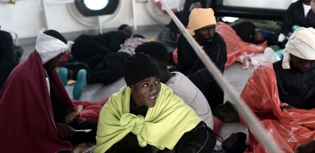 14.jun.2018 - Imigrante come comida fornecida pela guarda-costeira italiana dentro do navio Aquarius - Kenny Karpov/SOS Mediterranee/AFP