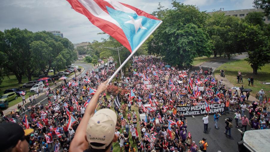 Pessoas marcham em San Juan um dia depois da renúncia do governador de Porto Rico, Ricardo Rosselló - Eric Rojas/AFP