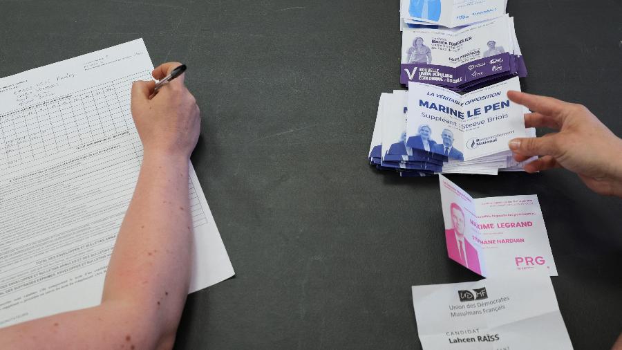 Um funcionário conta as cédulas para o primeiro turno das eleições parlamentares francesas, em uma estação de votação em Henin-Beaumont, França - REUTERS/Pascal Rossignol