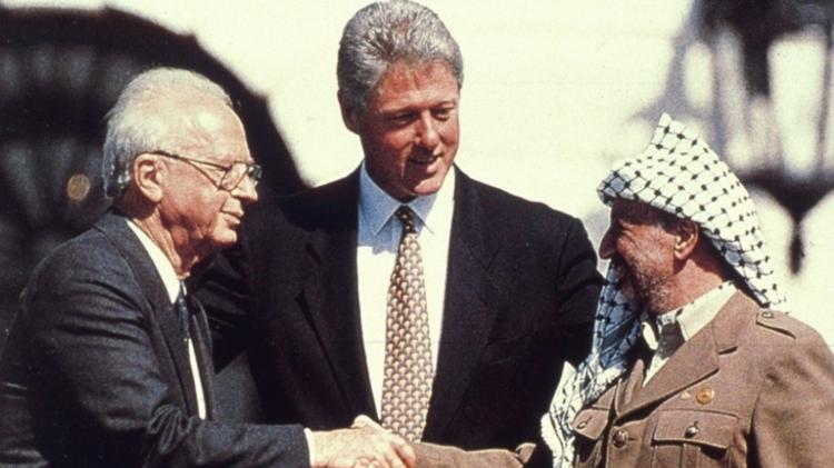  Acordos de Oslo: Yitzhak Rabin (esq) e Yasser Arafat se cumprimentam sob o olhar de Bill Clinton