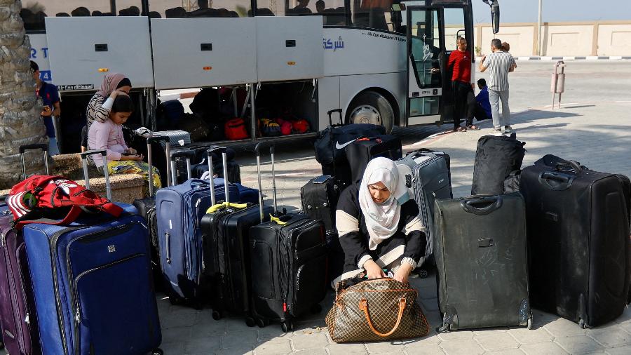 Palestinos aguardam para deixar Gaza na passagem de fronteira de Rafah com o Egito