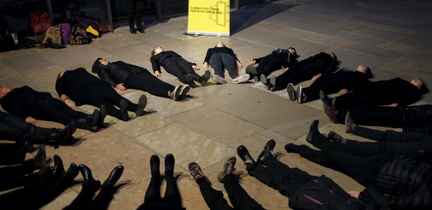 19.nov.2015 - Mulheres se deitam no chão em círculo durante a "Mulheres em Preto", performance criada pelos artistas espanhóis May Serrano e María Seco para protestar contra a violência de gênero na Espanha - Jon Nazca/Reuters