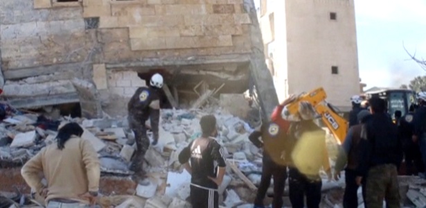 Pessoas se aglomeram diante de prédio destruído que seria um hospital apoiado pela ONG Médicos Sem Fronteiras, em Marat al Numan, Idlib, na Síria - Reuters