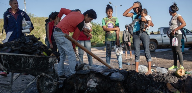 19.ago.2018 -  Venezuelanos observam os restos de suas roupas, alimentos e objetos que foram queimadas por moradores de Pacaraima (RR) durante protesto que expulsou temporariamente os imigrantes venezuelanos - Avener Prado/Folhapress