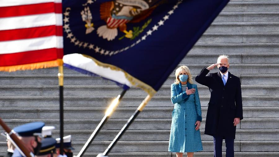 Presidente Joe Biden e a primeira-dama Jill Biden prestando continência em frente ao Capitólio - Pool/Getty Images
