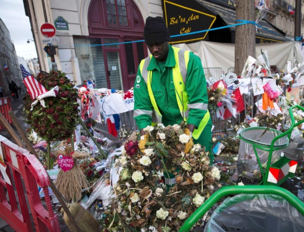 Funcionário retira flores murchas de memorial às vítimas do atentado no Bataclan - Eddie Keogh/Reuters