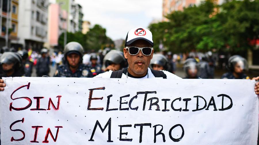 9.mar.2019 - Manifestante carrega cartaz com os dizeres "sem eletricidade, sem metrô" em protesto em Caracas, na Venezuela - Ronaldo Schemidt/AFP
