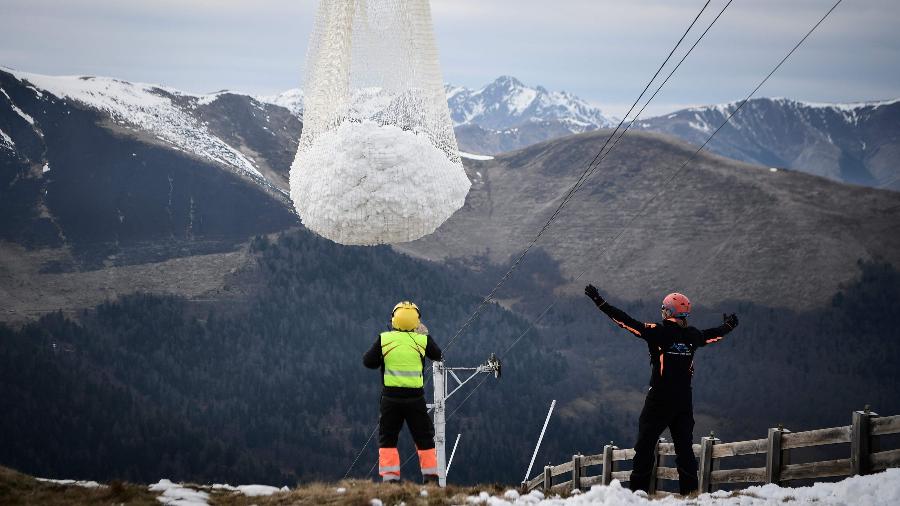 Funcionários de estação de esqui nos Pirineus participam de ação com helicóptero para retirar neve do topo de uma montanha - Anne-Christine Poujoulat/AFP
