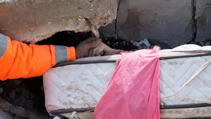 7.fev.2023 - O turco Mesut Hancer segurou a mão da filha de 15 anos, Irmak, que morreu após o terremoto que atingiu o país, até que ela fosse retirada dos escombros. A foto percorreu o mundo. - ADEM ALTAN/AFP