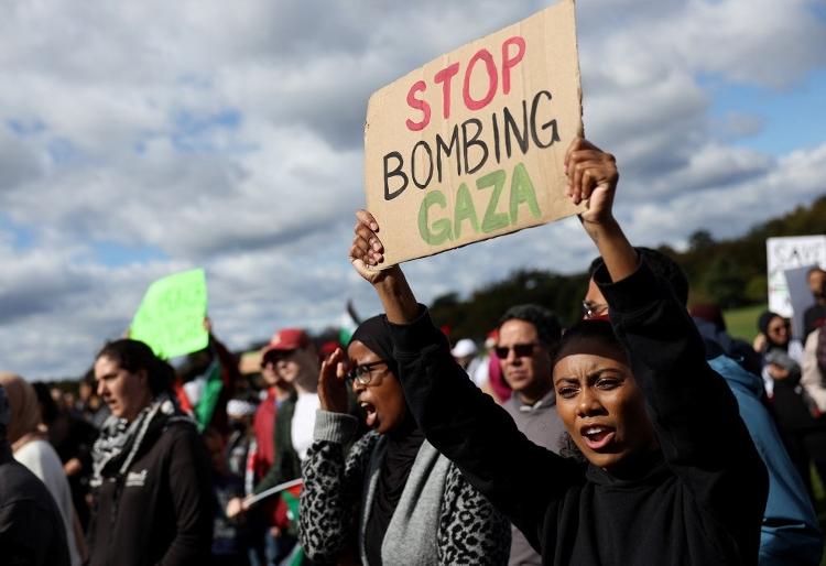 Manifestante em Washington D.C., nos EUA, pede "Parem de bombardear Gaza" em uma placa