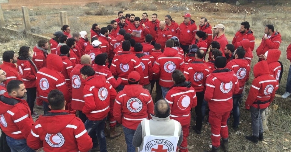 14.jan.2016 - Membros do comboio da Cruz Vermelha recebem instruções antes de saírem para levar ajuda humanitária à cidade sitiada de Madaya, na Síria. O grupo deve levar alimentos e medicações ao local