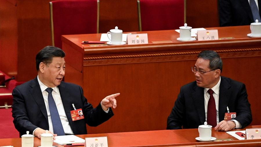 11.mar.23 - O presidente da China, Xi Jinping (à esquerda), fala com o recém-eleito primeiro-ministro Li Qiang (à direita) durante a quarta sessão plenária do Congresso Nacional do Povo (APN) no Grande Salão do Povo em Pequim - POOL/via REUTERS