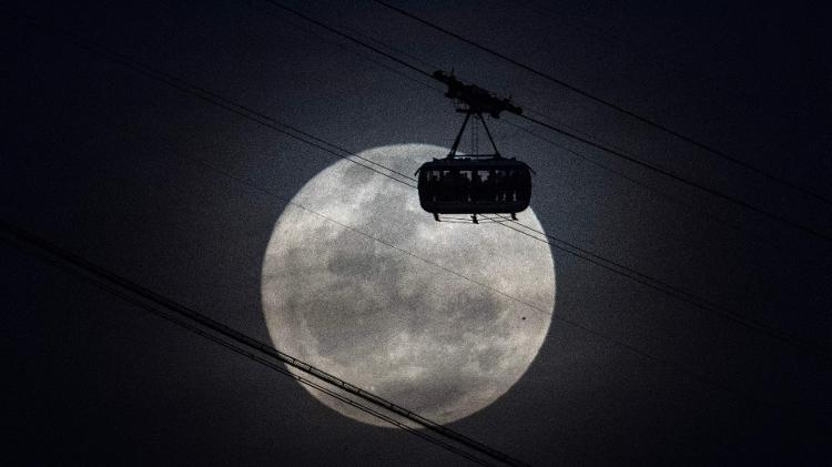 1º.ago.2023 - Superlua surge sobre o Pão de Açúcar, no Rio de Janeiro, por trás de teleférico