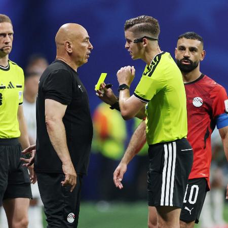 Técnico do Egito, Hossam Hassan, recebe um cartão amarelo do árbitro François Letexier na partida contra a Argentina Técnico do Egito, Hossam Hassan, recebe um cartão amarelo do árbitro François Letexier na partida contra a Argentina