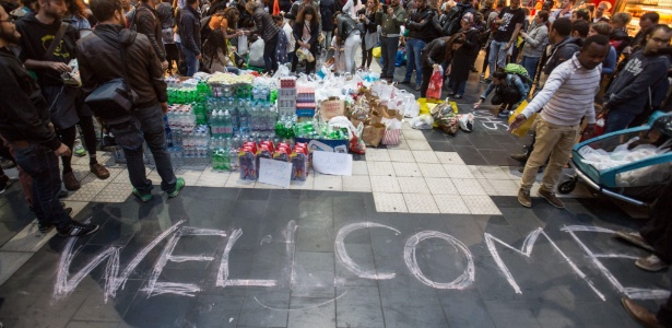 Suprimentos são colocados ao lado de uma grande mensagem de "Welcome" (bem-vindos) na estação de trem de Frankfurt, na Alemanha