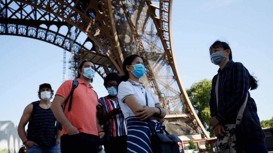 25.jun.2020 - Visitantes usando máscara fazem fila para entrar na Torre Eiffel, em Paris, reaberta parcialmente ao público - Thomas Samson/AFP