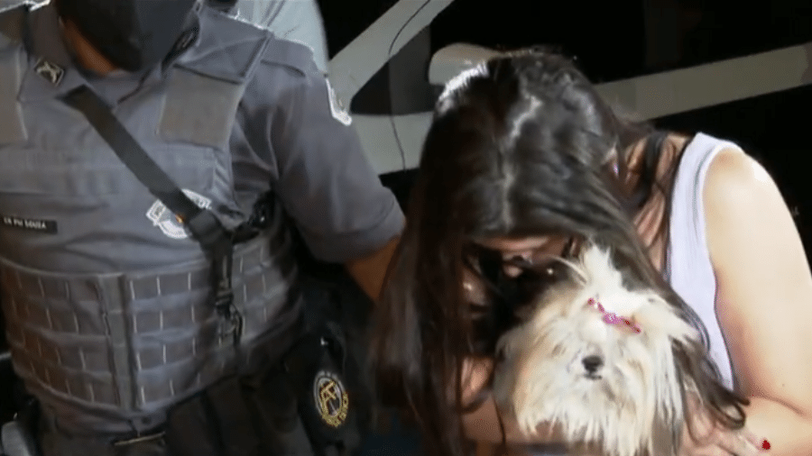 Suspeita chegou à delegacia com o cachorrinho no colo após ter usado o animal como disfarce para esconder armas - Reprodução TV Globo/Bom Dia São Paulo