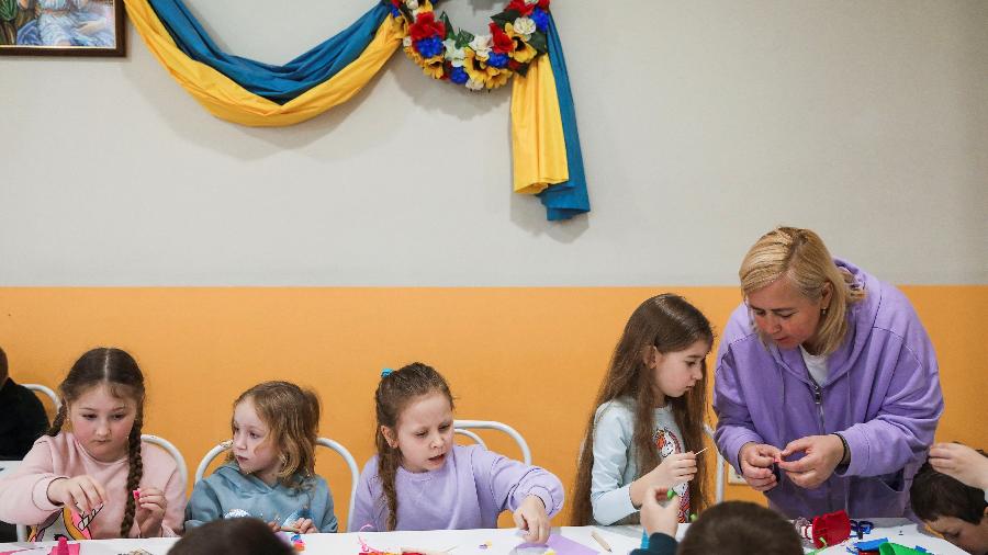 28.mar.2022 - Oksana Koziy, diretora do Centro Cultural e Educacional Ucraniano Berehynia, atende crianças ucranianas que participam de uma sessão de artesanato, após fugirem da invasão russa da Ucrânia, em Atenas, Grécia - Louiza Vradi/Reuters