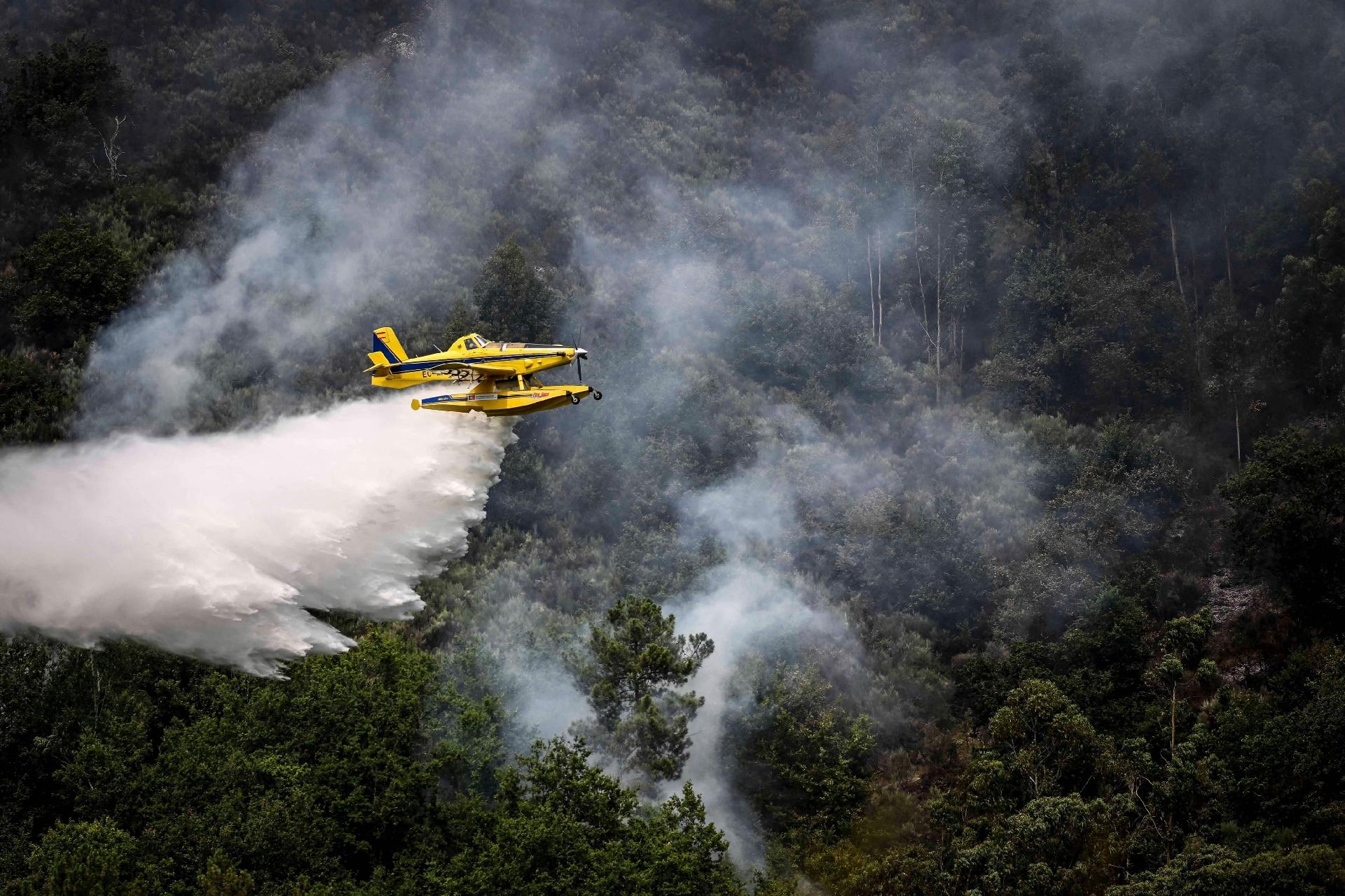 An airplane pours water on a fire near Bustelo in northern Portugal's Amarante region on July 16, 2022.  - PATRICIA DE MELO MOREIRA/AFP