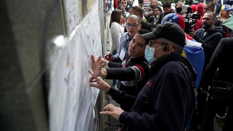 Venezuelanos verificam seus locais de votação no dia da eleição presidencial em um local de votação no Colégio Técnico Palermo, em Bogotá, Colômbia