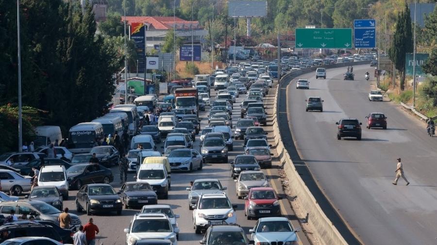 Veículos esperam no trânsito na cidade de Damour, ao sul da capital Beirute, em 24 de setembro de 2024, enquanto as pessoas fogem do sul do Líbano