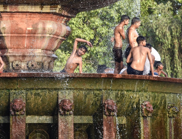 Meninos brincam em uma fonte em uma tarde quente de calor em Nova Deli, na Índia - Saumya Khandelwal/The New York Times