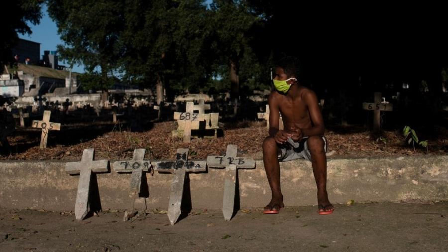 Jovem trabalha em cemitério no Rio de Janeiro durante a pandemia de covid-19 - Getty Images