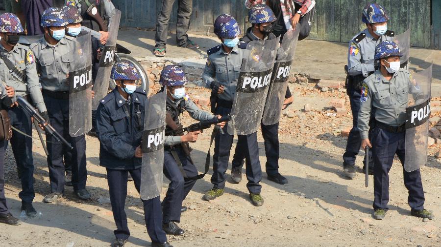 Policiais entram em confronto com manifestantes na cidade de Kale, em Mianmar, durante protesto contra o golpe militar - STR/AFP