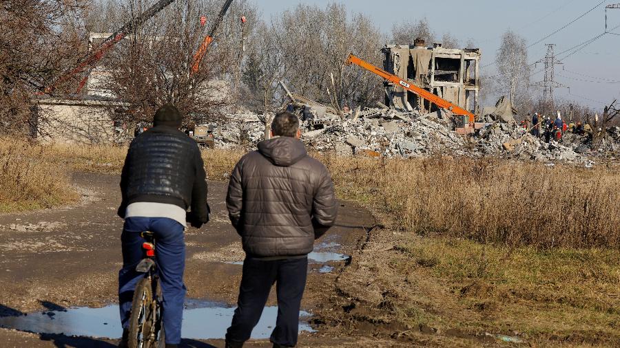 Homens observam destroços de local destruído em ataque ucraniano; pelo menos 89 soldados russos morreram, diz Kremlin - ALEXANDER ERMOCHENKO/REUTERS