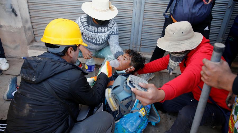 09.jan.23 - Manifestantes ajudam um homem ferido durante um confronto com forças de segurança, durante um protesto exigindo eleições antecipadas e a libertação do ex-presidente preso Pedro Castillo, perto do aeroporto de Juliaca, no Peru - STRINGER/REUTERS