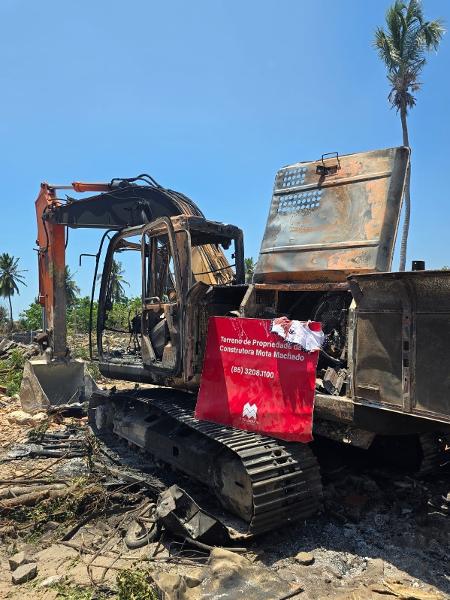 Retroescavadeira queimada durante revolta de ocupantes de terreno