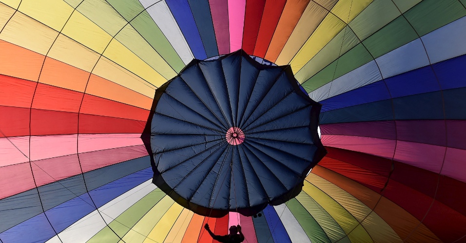 7.ago.2015 - Silhueta de homem preparando balão de ar, no festival Internacional de Bristol, no Reino Unido
