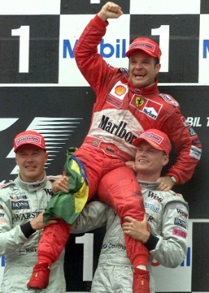 Barrichello comemora vitória erguido por Mika Hakkinen (E) e David Coulthard - REUTERS/Reinhard Krause