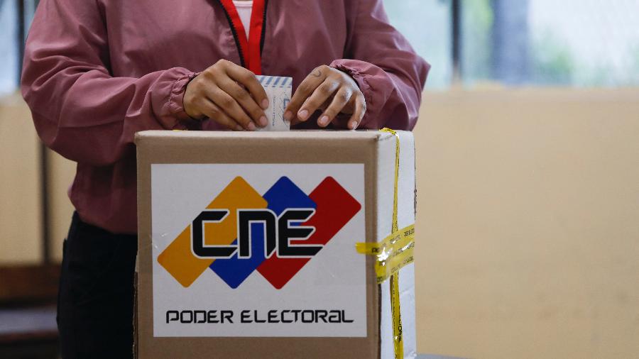 3.dez.2023 - Mulher deposita voto em urna