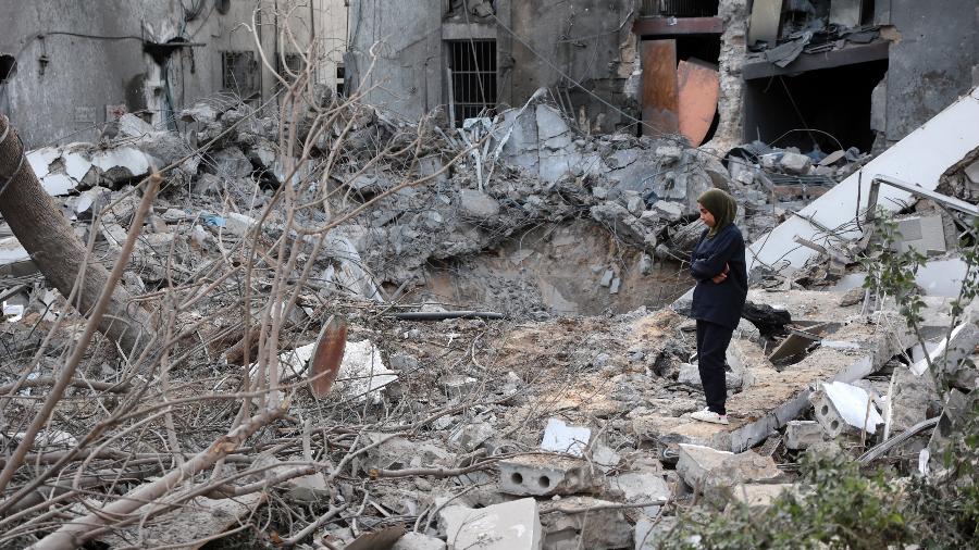 Mulher em meio aos escombros após um ataque israelense ao hospital Al-Ahli, em Gaza