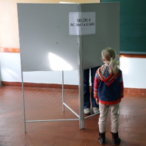 Criança espera a mãe votar em seção eleitoral em Lisboa - Tiago Petinga/Efe