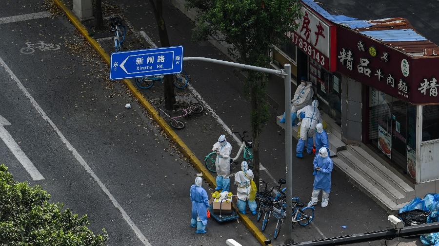 Profissionais de saúde usam equipamento de segurança na rua durante lockdown para conter covid-19 em Xangai, na China - Hector Retamal/AFP