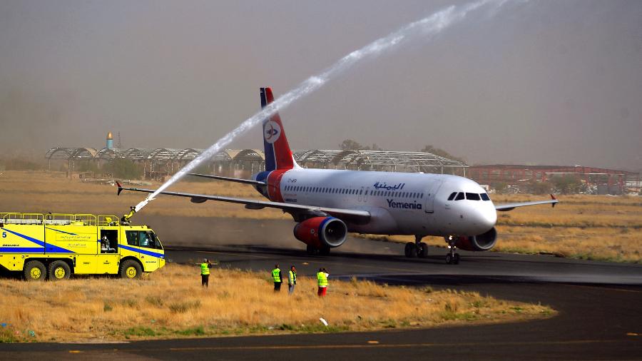 16.mai.22 - Um caminhão de bombeiro comemora com jato d"água o primeiro voo da Yemen Airways em seis anos na pista do aeroporto de Sanaa, na capital iemenita - MOHAMMED HUWAIS/AFP