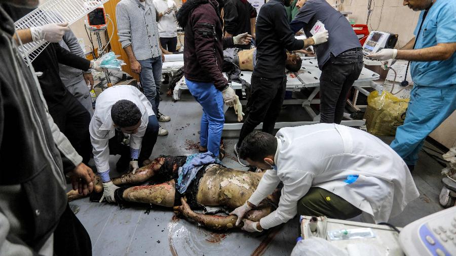 8.jan.2024 - No Hospital Shuhada al-Aqsa, em Gaza, médicos movem corpo de homem morto durante bombardeio de Israel