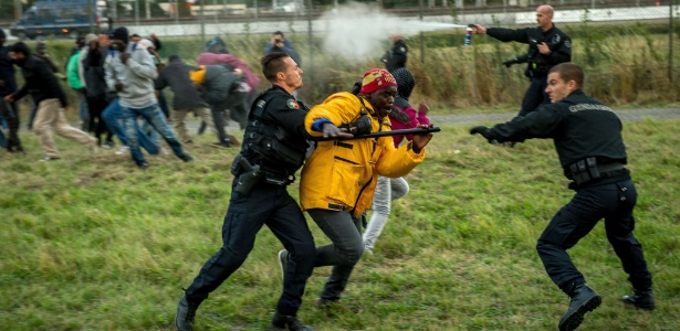 29.jul.2015 - Policiais franceses tentar impedir imigrantes de entrarem no Eurotúnel - Phillipe Huguen/AFP