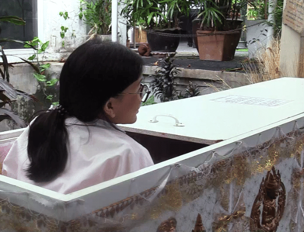 Cliente entra em caixão instalado no café Kid Mai, na Tailândia. Segundo o proprietário, ensinamento budista diz que quem pensa na morte se torna menos egoísta - EFE