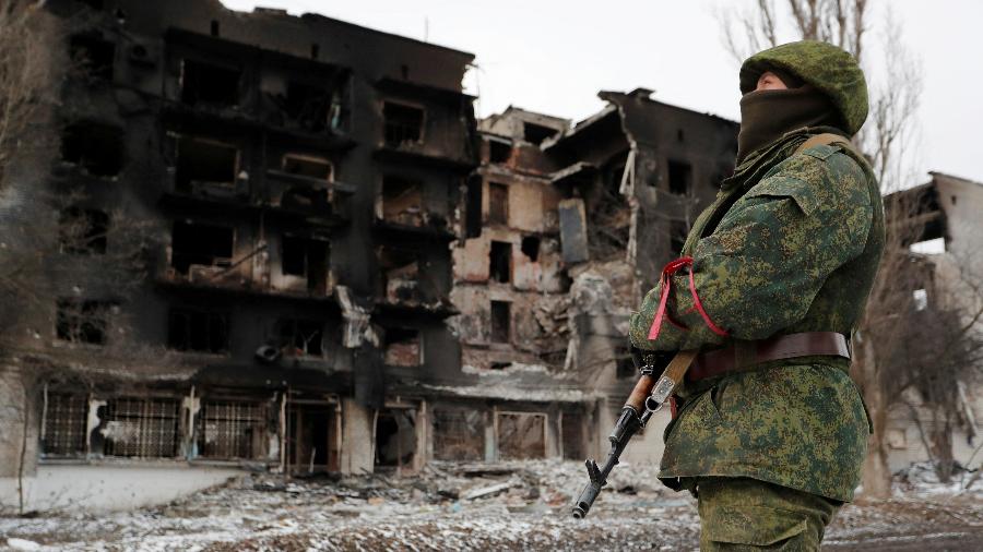 Soldado de tropa separatista pró-Rússia próximo a escombros de prédio atingido pela guerra com a Ucrânia - ALEXANDER ERMOCHENKO/Reuters