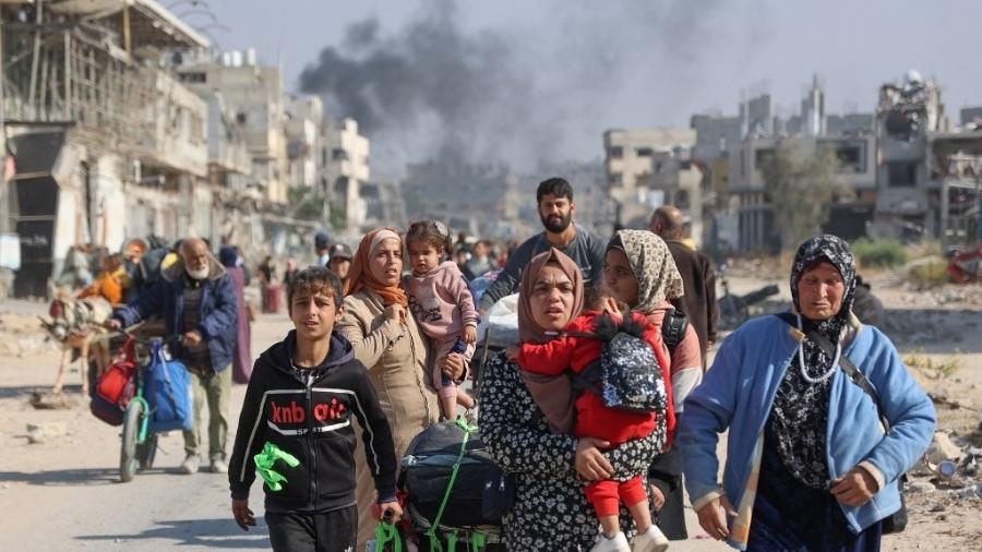 Palestinos deslocados de abrigos em Beit Hanoun cruzam a estrada principal de Salaheddine para Jabalia, no norte da Faixa de Gaza, após ordens de evacuação do exército israelense em 12 de novembro de 2024 - OMAR AL-QATTAA/AFP