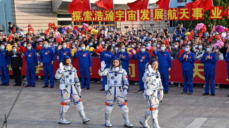 Os taikonautas Gui Haichao (esq.), Zhu Yangzhu (centro) e Jing Haipeng (dir.) acenam para o público antes de embarcarem no foguete Long Marcha 2F, em direção à estação espacial Tiangong - Hector Retamal/AFP