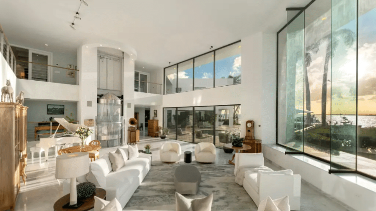 A sala da mansão conta com o famoso elevador de vidro ao fundo
