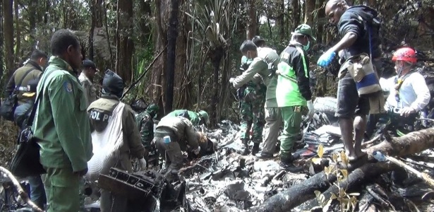 Agentes de resgate trabalham no local onde caiu o avião da Trigana Air, no domingo (16) - AFP
