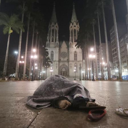 Morador de rua se abriga do frio enquanto dorme durante a madrugada em frente da Cadetral da Sé  - Alex Silva/Estadão Conteúdo