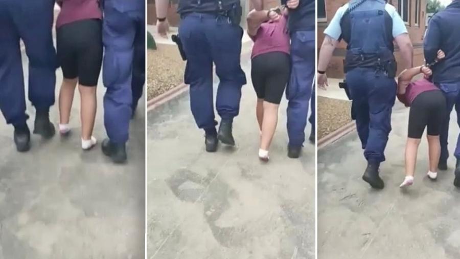No vídeo é possível ver a menina gritando enquanto está algemada e é puxada por outros dois policiais homens - Reprodução/9news