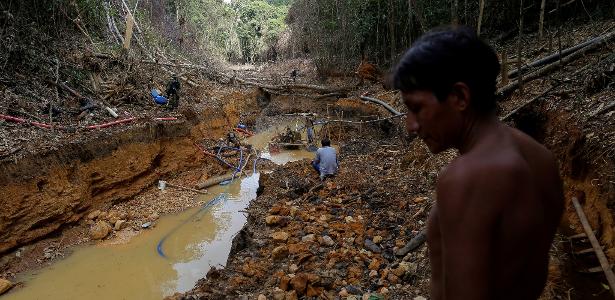 Indígena yanomami acompanha agentes do Ibama durante operação contra garimpo ilegal na floresta amazônica