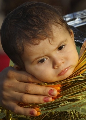 Criança síria é coberta com manta térmica ao chegar a Kos, na Grécia - Yannis Behrakis/Reuters